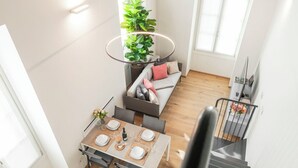 Un intérieur moderne comprenant un coin repas, un canapé et un escalier.