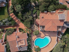 An aerial view of a property with a swimming pool, terracotta-tiled roofs, and landscaped gardens. - Lovely Flat Only 350 m From the Beach (Arzachena)
