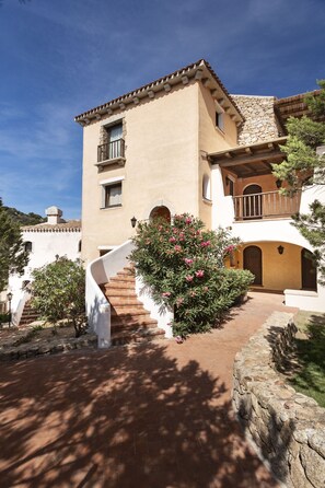 Un bâtiment à deux étages, doté d’une façade en pierre, d’un balcon et d’un escalier menant à l’entrée.