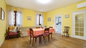 A dining area with a table and chairs, a sofa, and a chair. - Ca' Mercati Apartment with Two Bedrooms in Mestre Venice (Venezia)