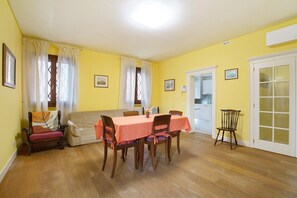 A dining area with a table and chairs, a sofa, and a chair. - Ca' Mercati Apartment with Two Bedrooms in Mestre Venice (Venezia)