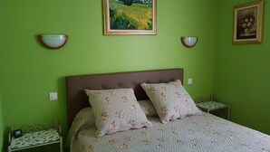 A bedroom with a bed, two nightstands, and two wall-mounted lamps.