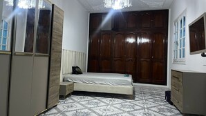 Un dormitorio con cama, armario y un espejo grande.
