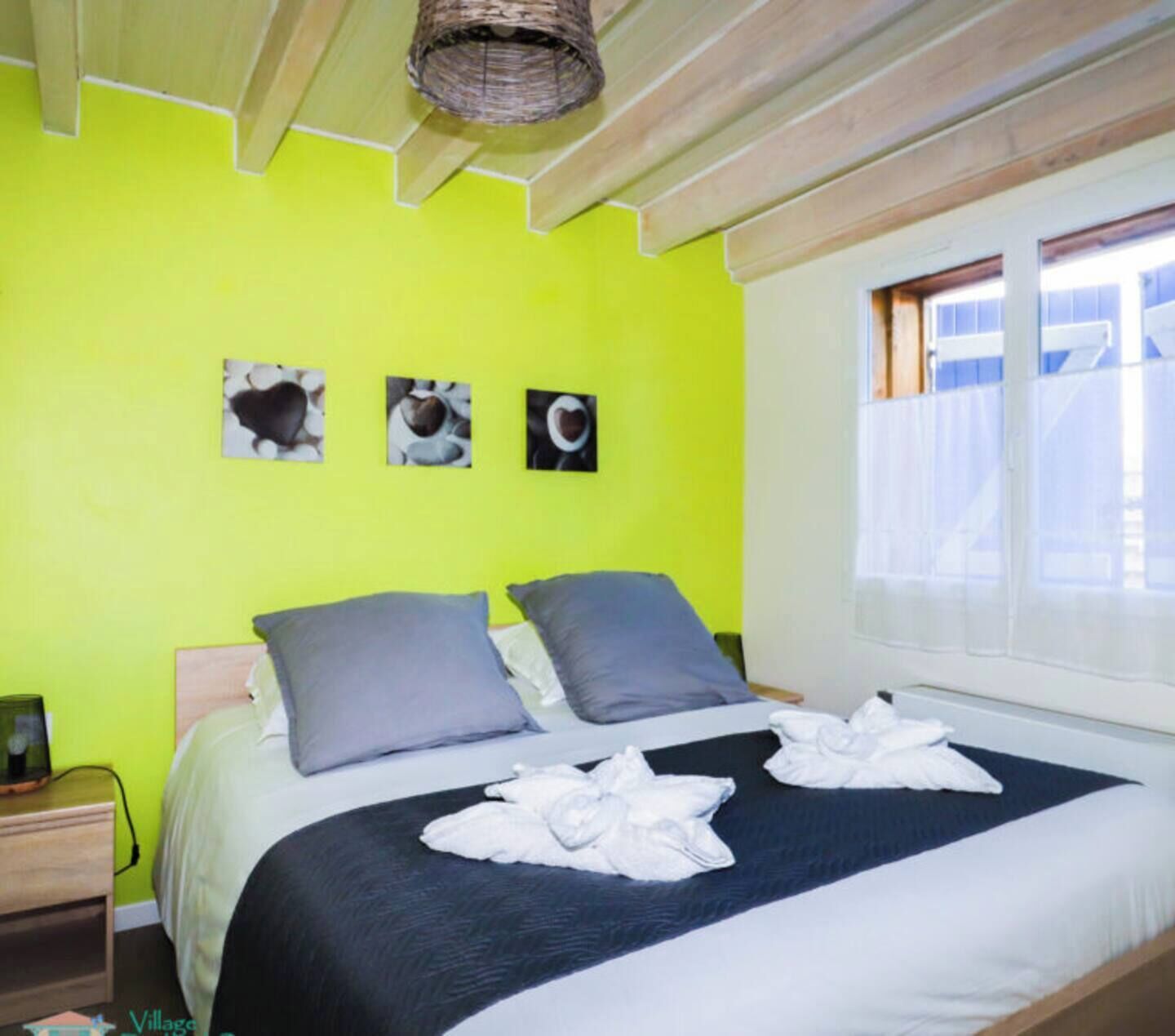 A bright green room with a bed, pillows, and a window.