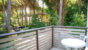 A balcony with a wooden railing, a white table, and chairs. - Comfy Accommodation With Balcony (Eraclea)