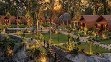 Un resort con varias cabañas, un camino central y un jardín ajardinado.