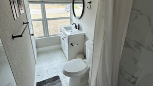 Une salle de bain avec des toilettes, un lavabo et un rideau de douche.
