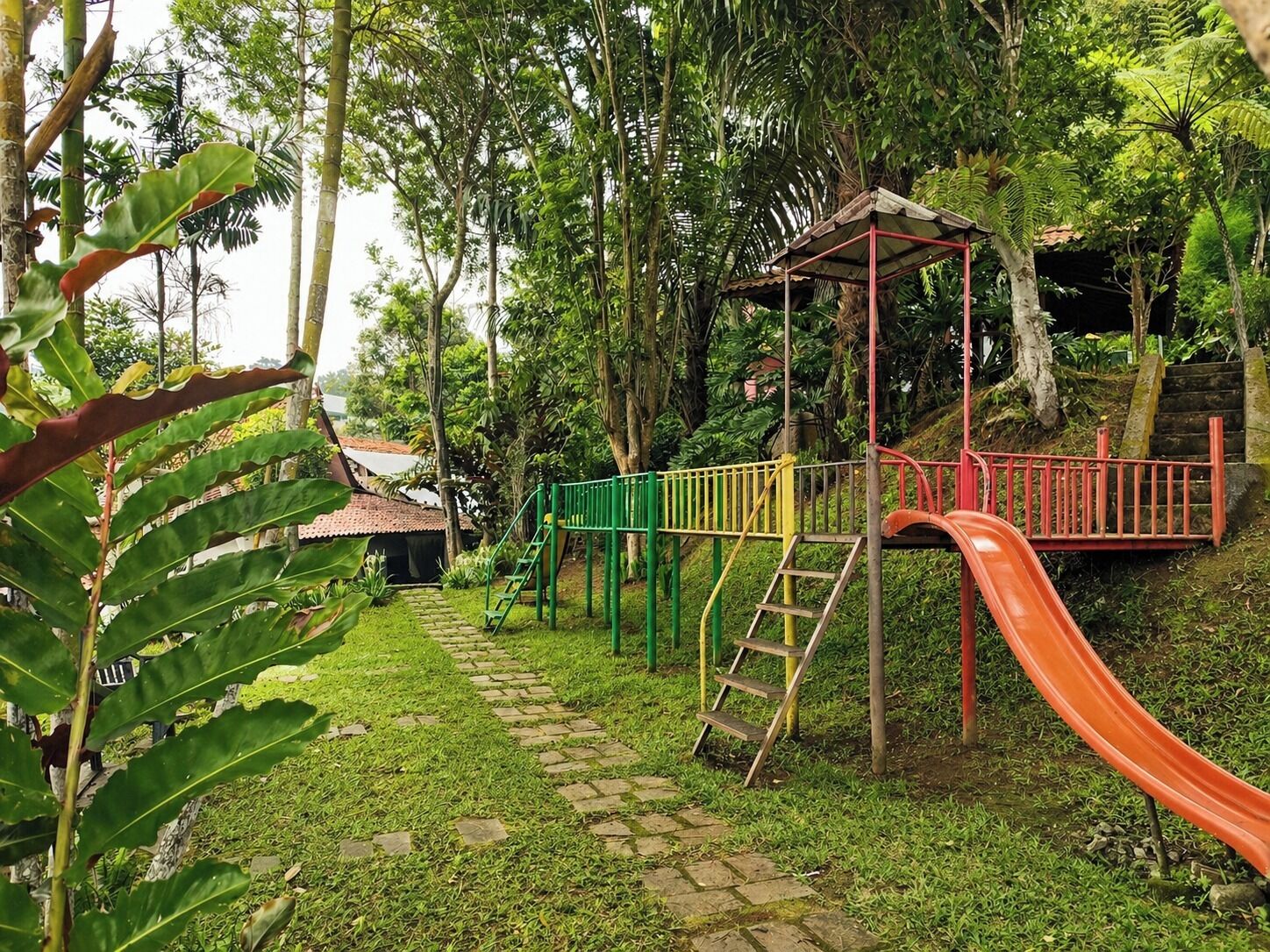 Une aire de jeux avec un toboggan, des structures d’escalade et un espace abrité.