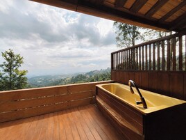 Una terraza de madera con un lavamanos integrado y vistas al paisaje.