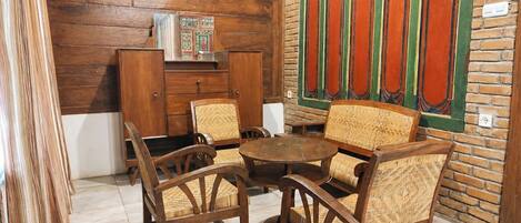 A room with wooden furniture, including a table and chairs, a cabinet, and a decorative wall panel.