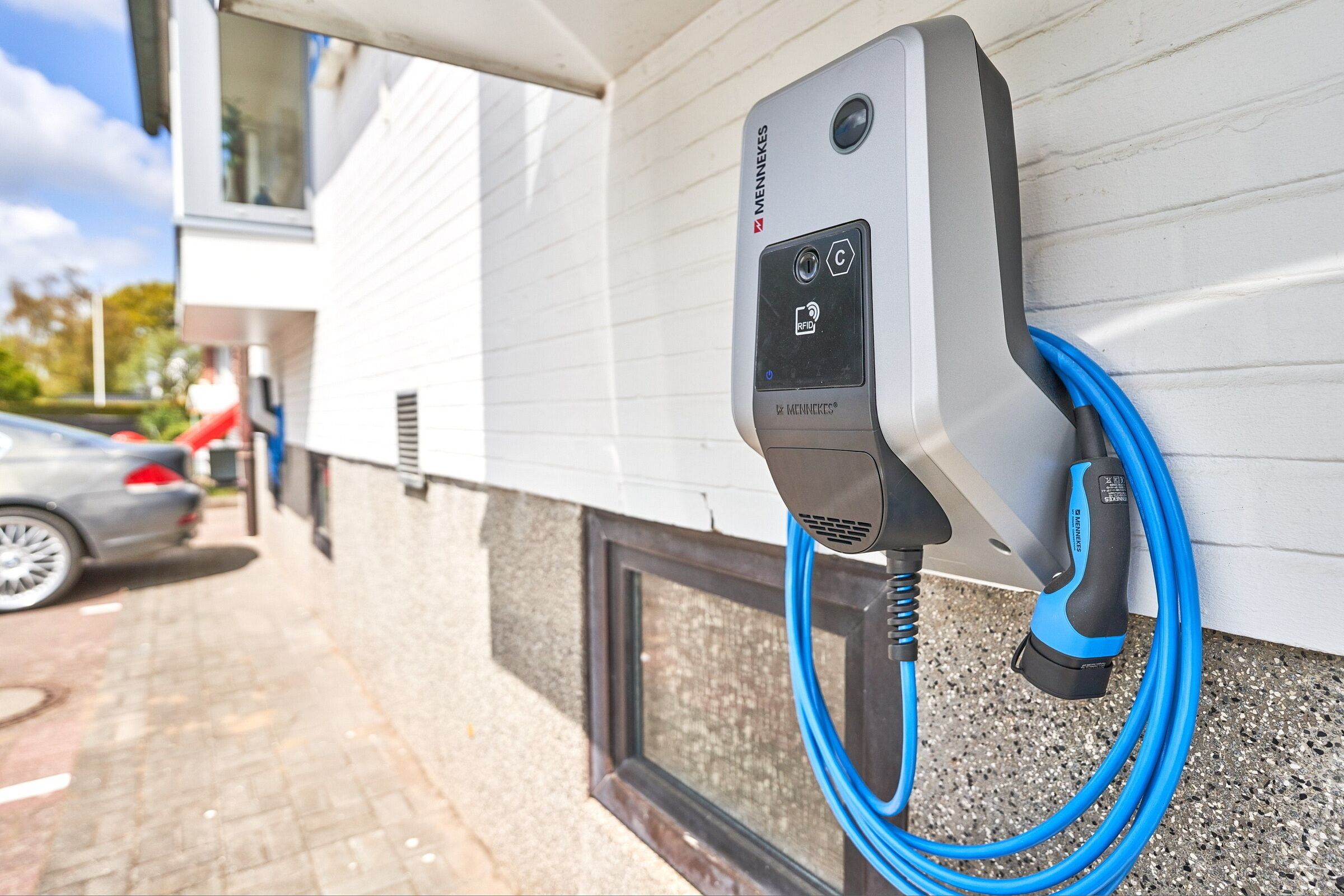 Een laadstation voor elektrische voertuigen, bevestigd aan de buitenmuur van een gebouw.