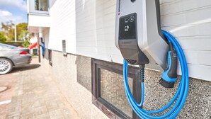 Eine Ladestation für Elektroautos an der Außenwand eines Gebäudes.