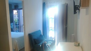 A compact living space with a dining area, a blue sofa, and a small table. - Le Derroja - Perpignan (Perpignan)