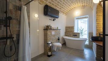 Une salle de bain moderne équipée d’une douche, de toilettes et d’une baignoire.