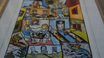 A framed comic-style artwork with various panels depicting scenes of people and animals in different settings.