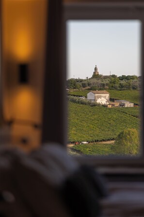 A rural landscape with a small house and a church on a hill.