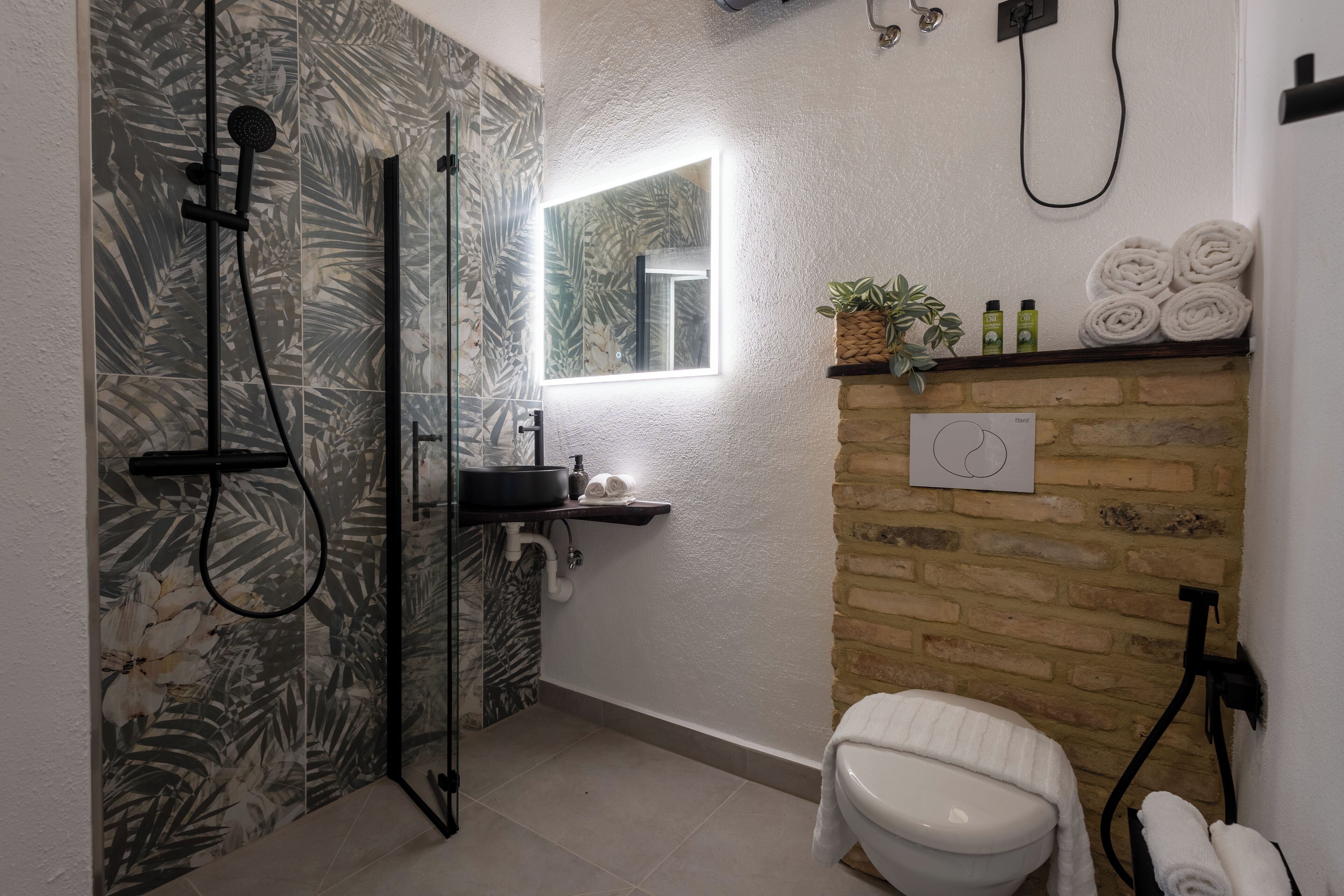 Une salle de bain avec douche, toilettes et lavabo.