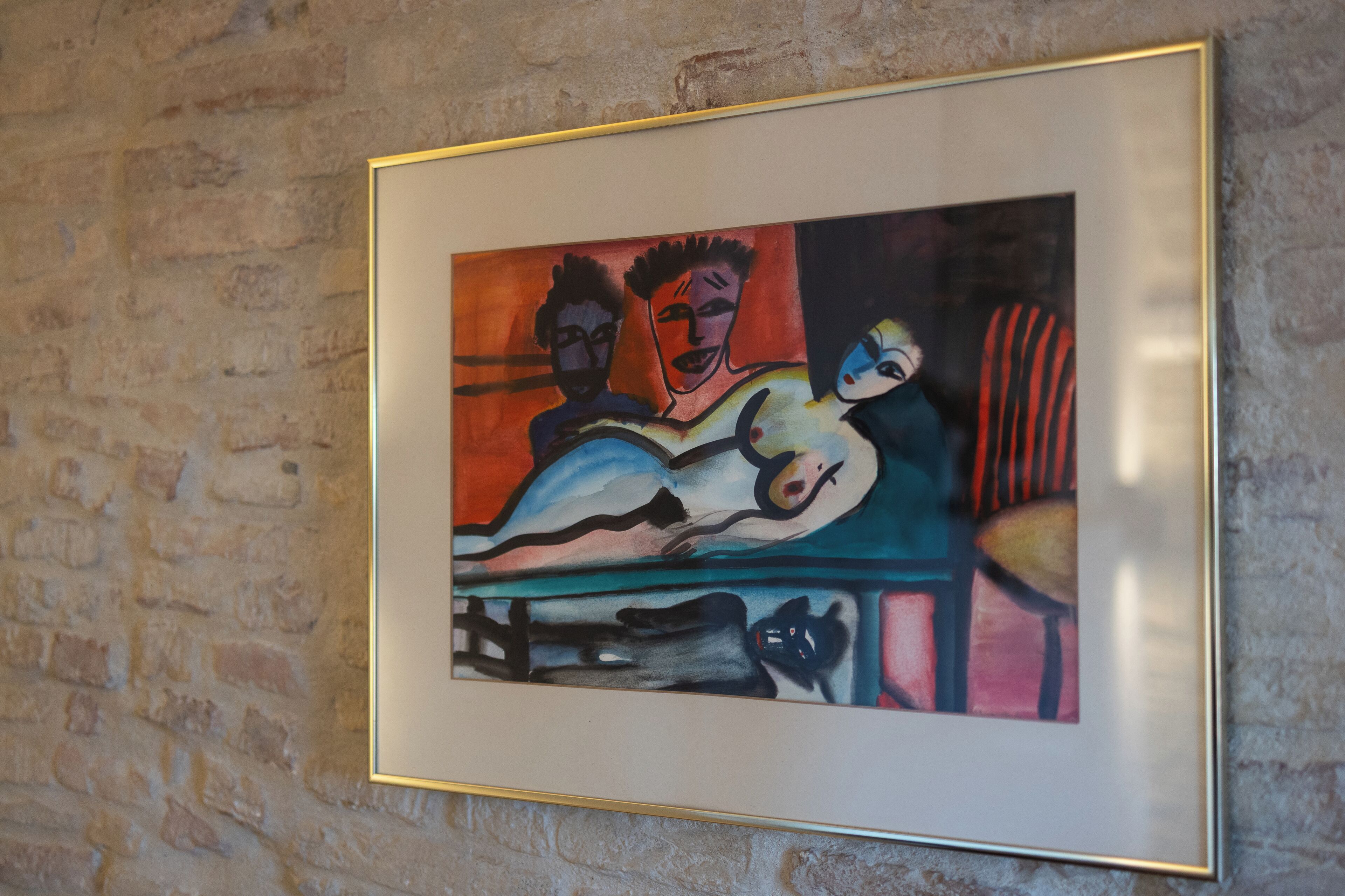 A framed painting on a brick wall.