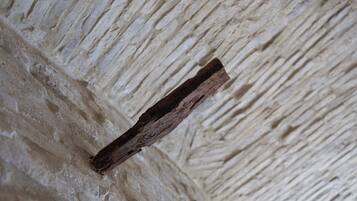A textured wall with a wooden beam.