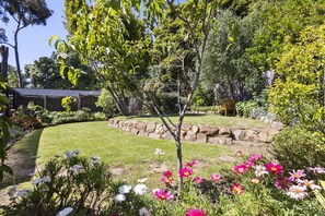 A well-maintained garden with a variety of flowering plants and a neatly trimmed lawn. - Cooinda, Red Hill South (Red Hill South)