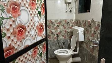 Une salle de bain avec des toilettes, un lavabo et une douche.