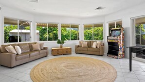 Un salon spacieux avec deux canapés, une table basse et un grand tapis tissé.