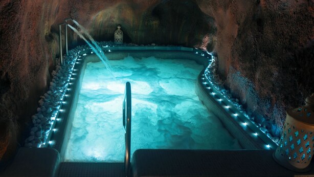 A spa area with a hot tub surrounded by rocks and a decorative lantern. - CASA RURAL & SPA LA GRAJA (Chinchón)