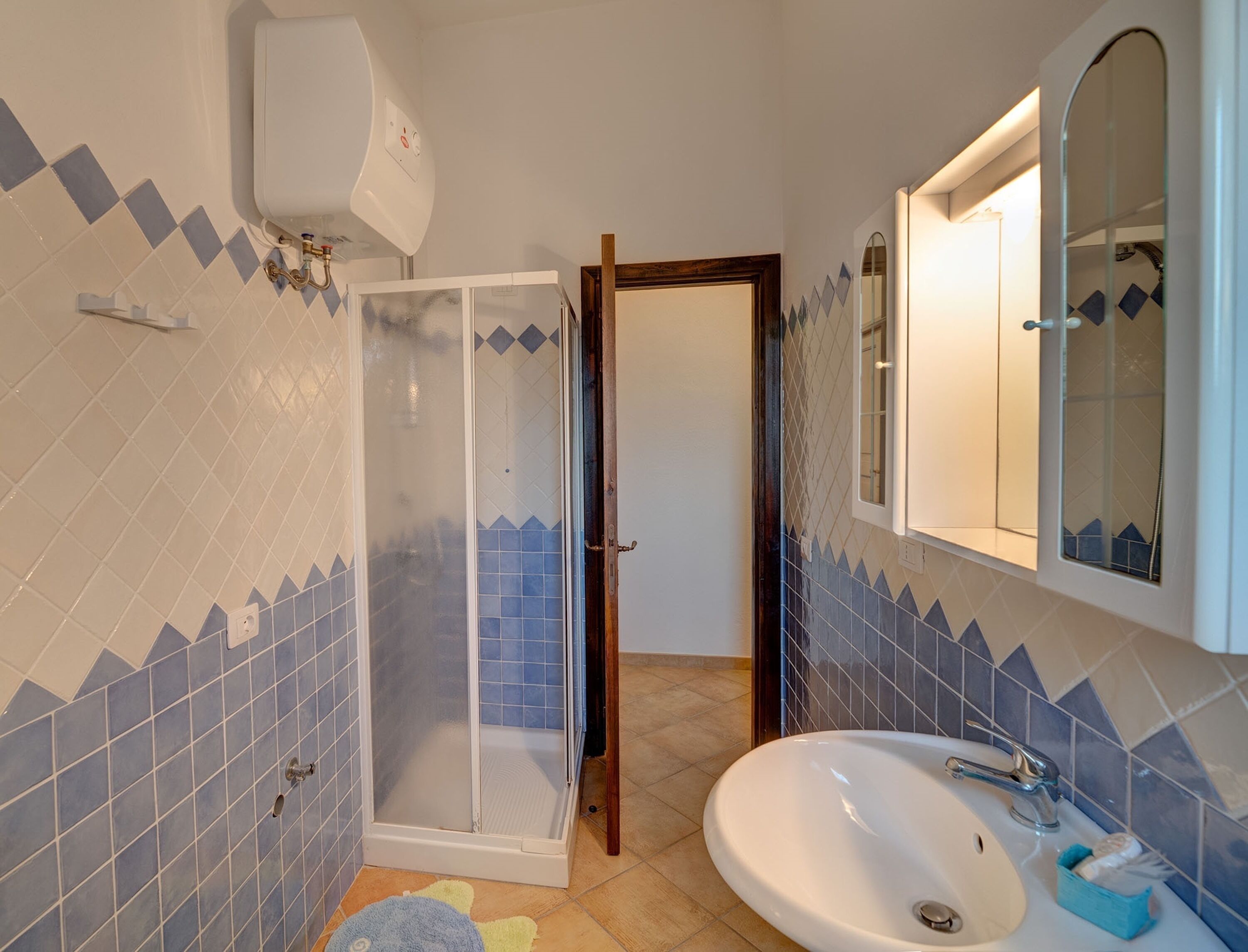 A bathroom with a shower, sink, and mirror.