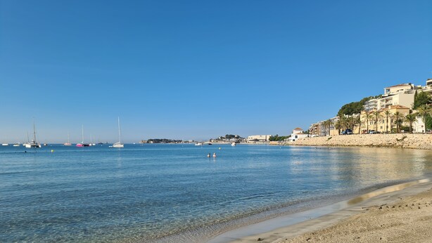 A beach with clear water, boats, and buildings along the shore. - Charming Provençal Cottage, 900 m from the Beach (Sanary-sur-Mer)