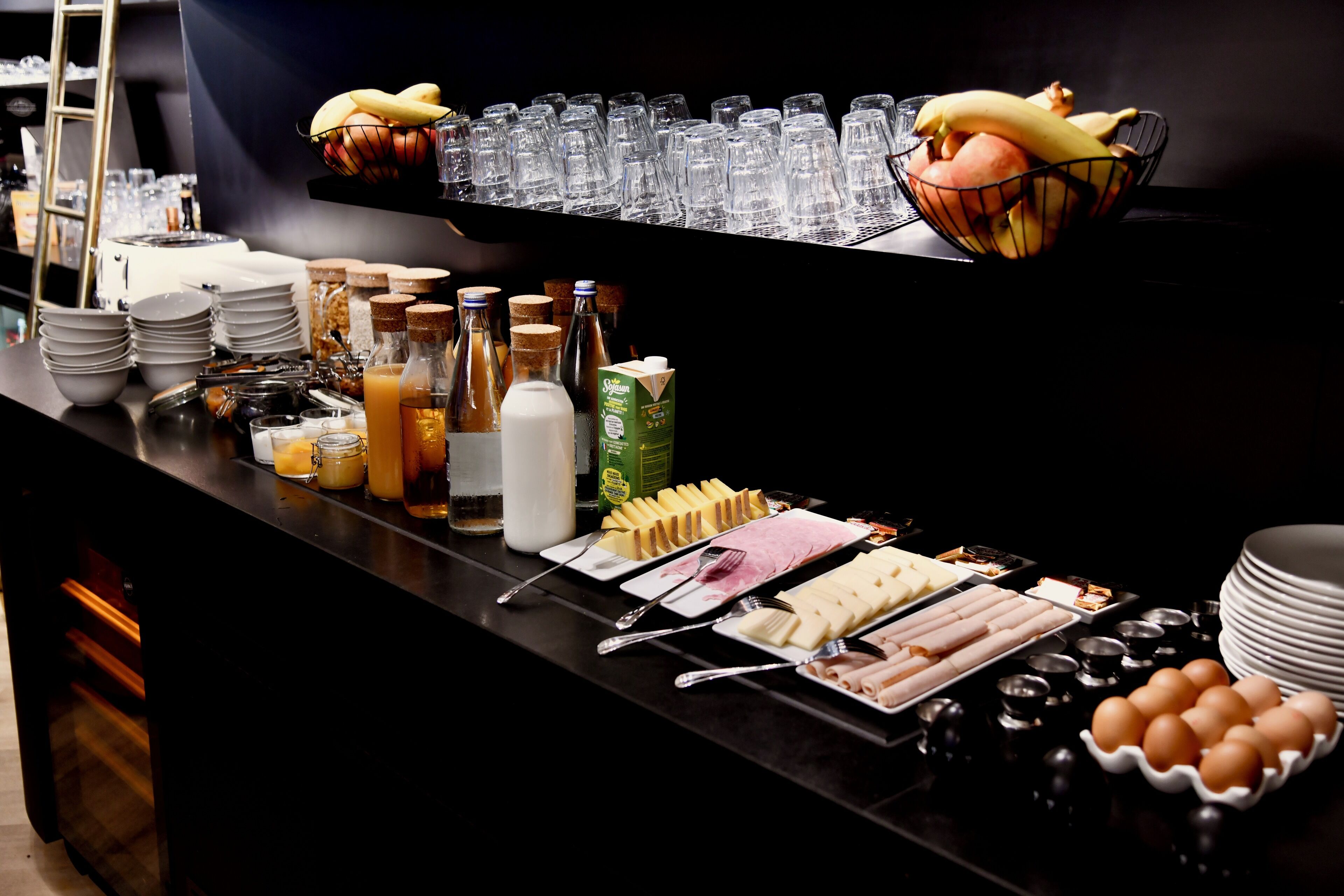 Un buffet proposant une variété de plats, de boissons et d’ustensiles.