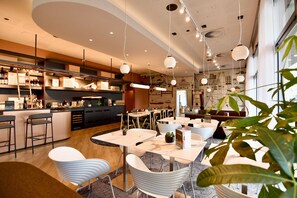 Un ristorante moderno con zona bar, posti a sedere e lampade a sospensione.