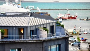 A modern building with a balcony overlooking a marina with boats. - ibis Budget Brest Centre Port (Brest)
