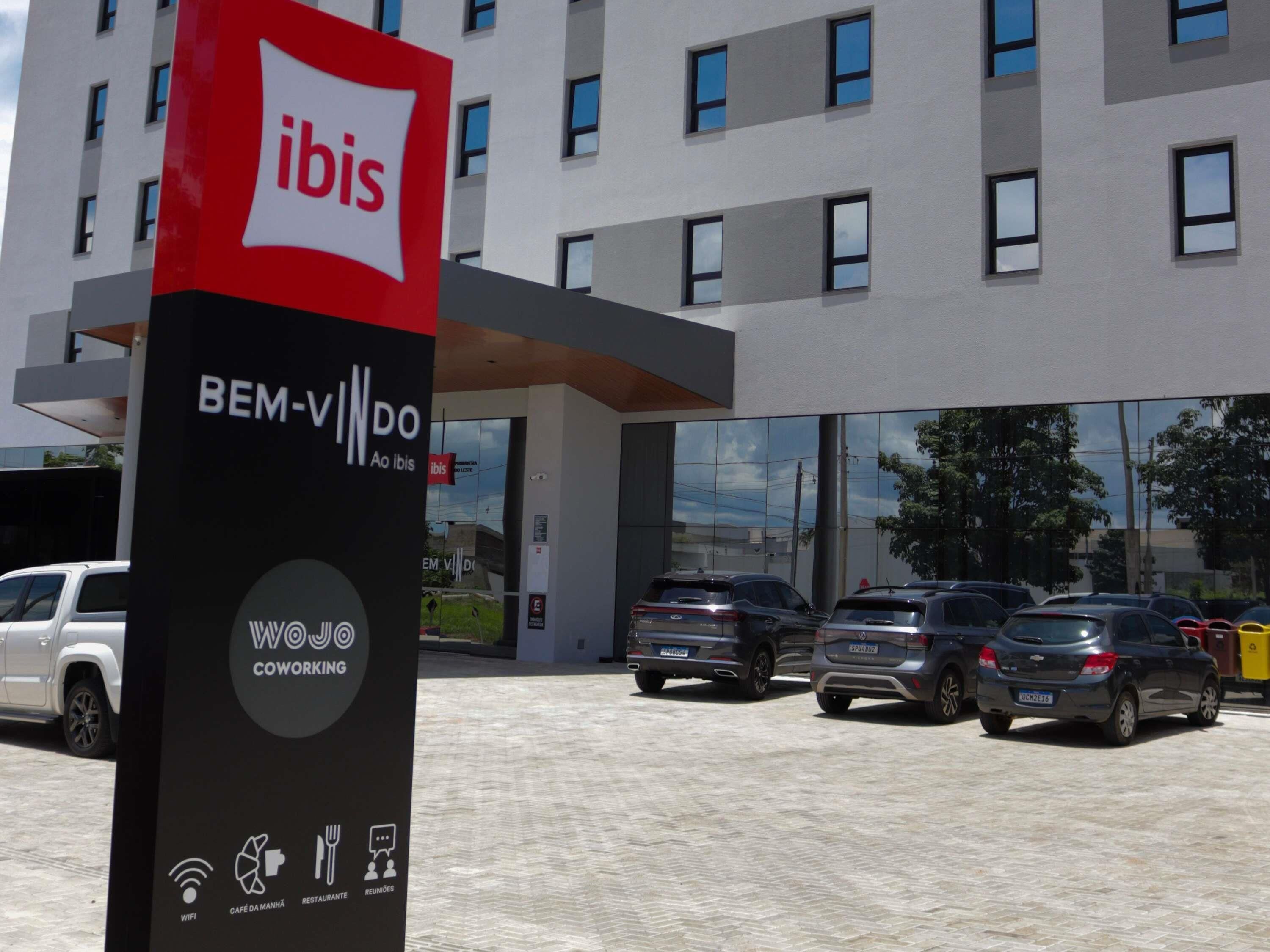 Un edificio moderno con un letrero que dice 'ibis' y 'BIENVENIDO'.