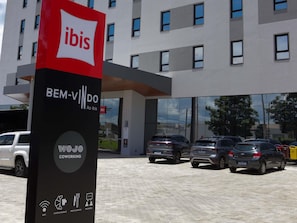 A modern building with a sign for 'ibis' and 'BEM-VINDO'. - ibis Primavera Do Leste (Primavera do Leste)