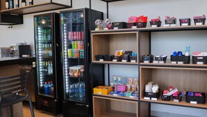 A self-service kiosk with beverage dispensers and shelves stocked with snacks and toiletries. - ibis Primavera Do Leste (Primavera do Leste)