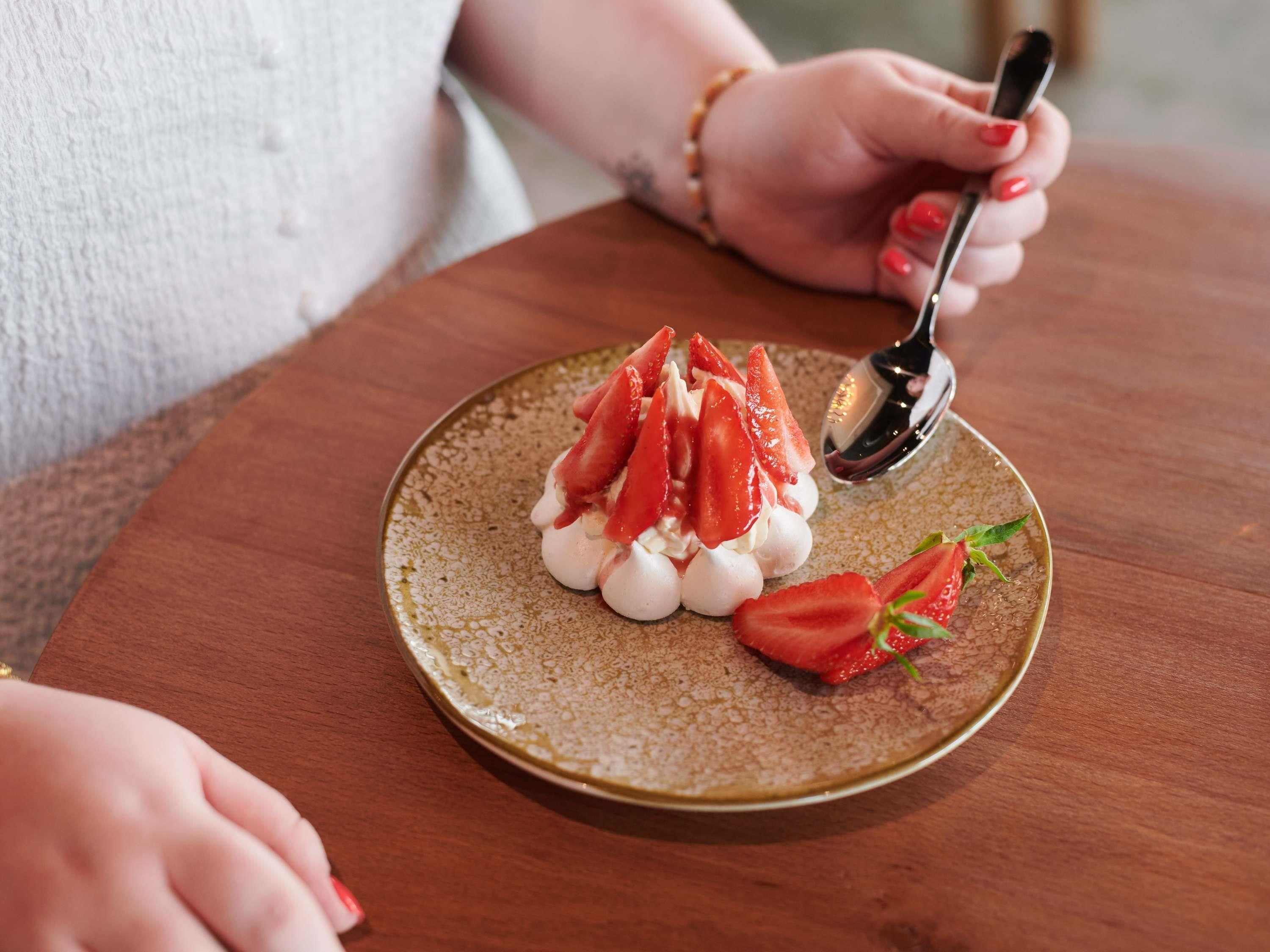 Un postre en un plato de cerámica con una cuchara.