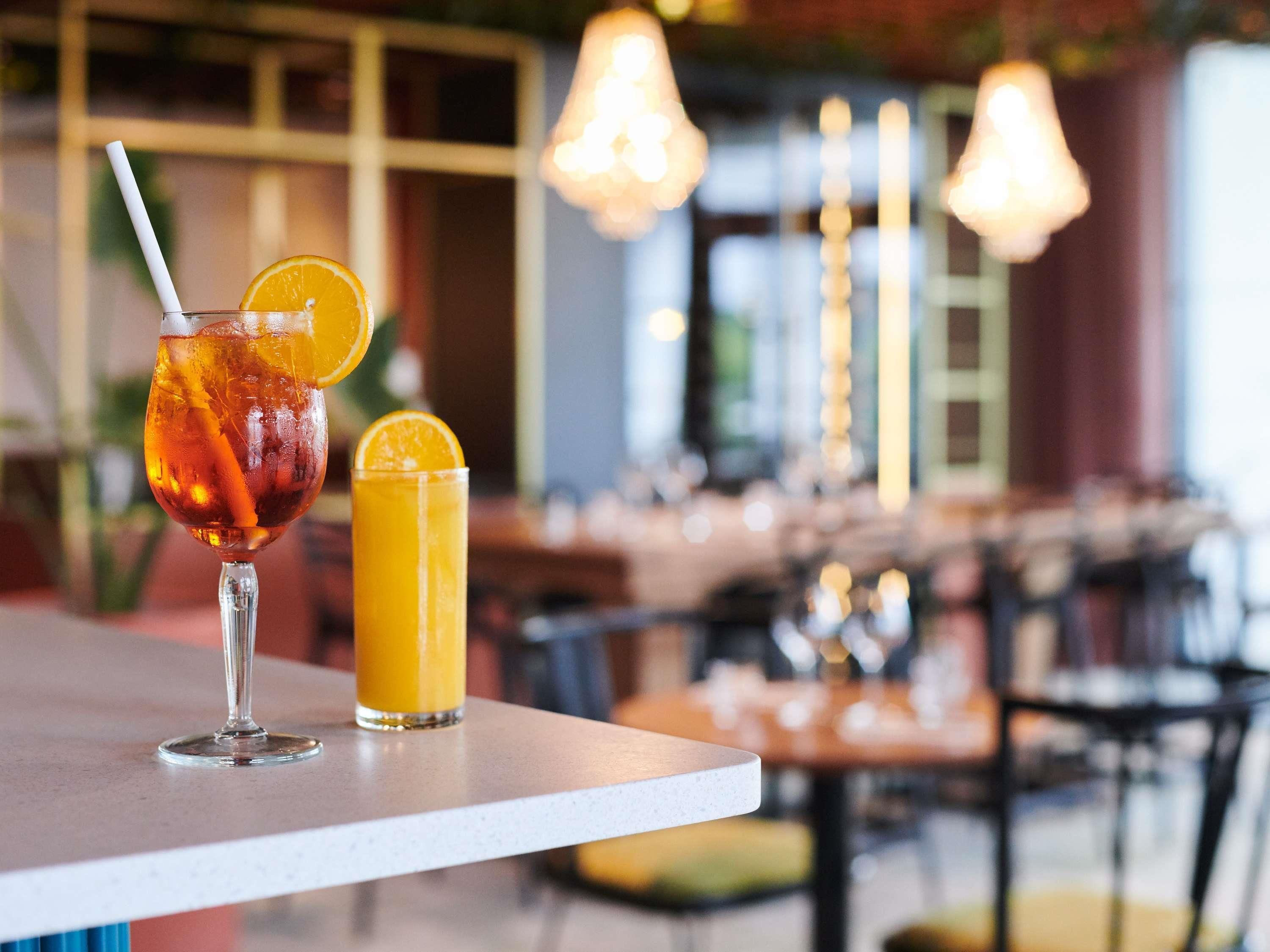 Dues begudes sobre una taula, amb un fons borrat d'un interior de restaurant.