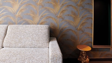 Een bank met een structuurweefsel, een muur met behang met patroon, en een ronde tafel met houten poten.