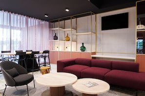 Ein modernes Interieur mit einem roten Sofa, einem runden Tisch, einem schwarzen Stuhl und einem Essbereich mit Stühlen und Tisch.