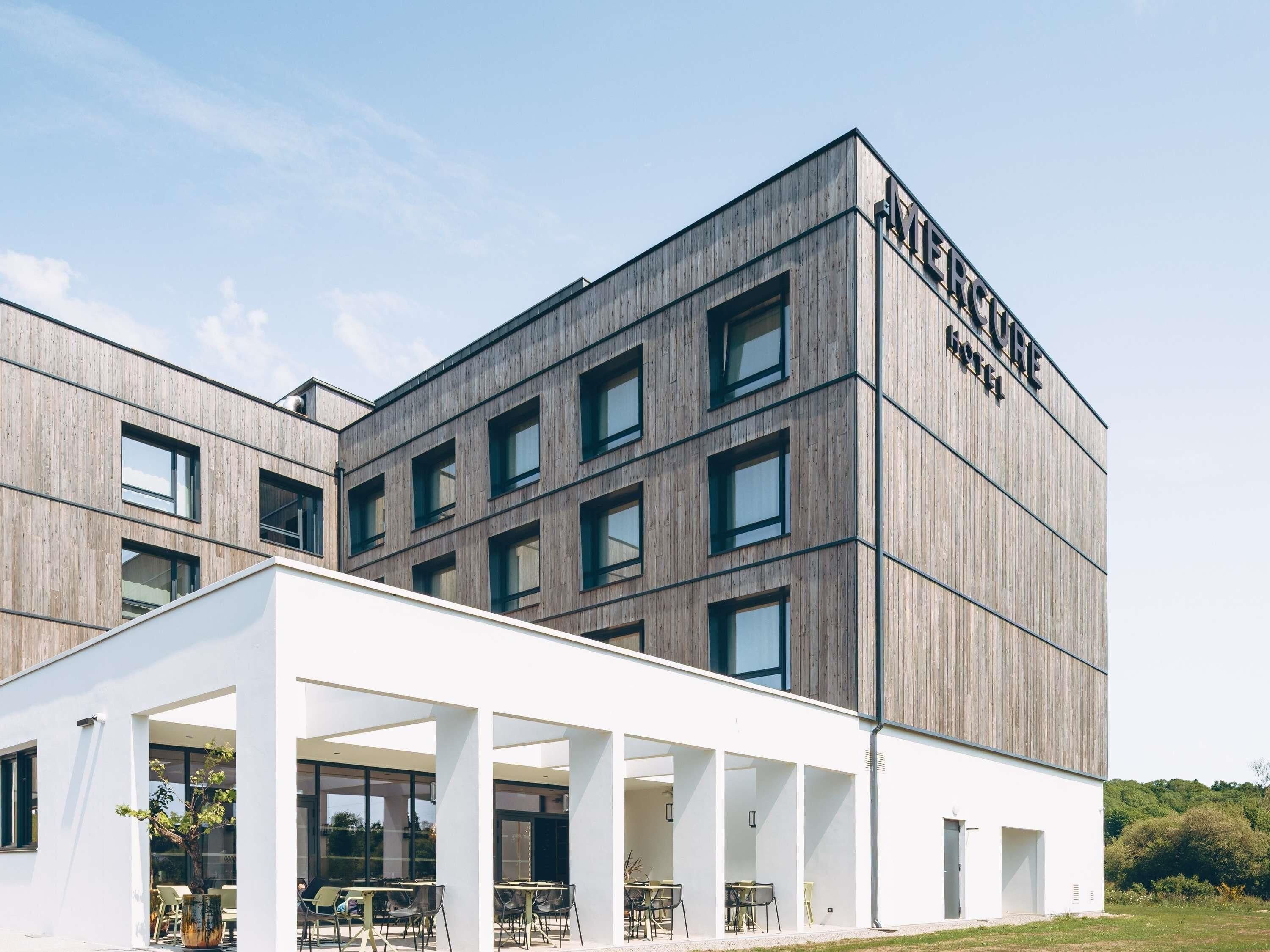 Un bâtiment moderne doté d’un toit plat et d’une enseigne indiquant « HÔTEL METRO ».