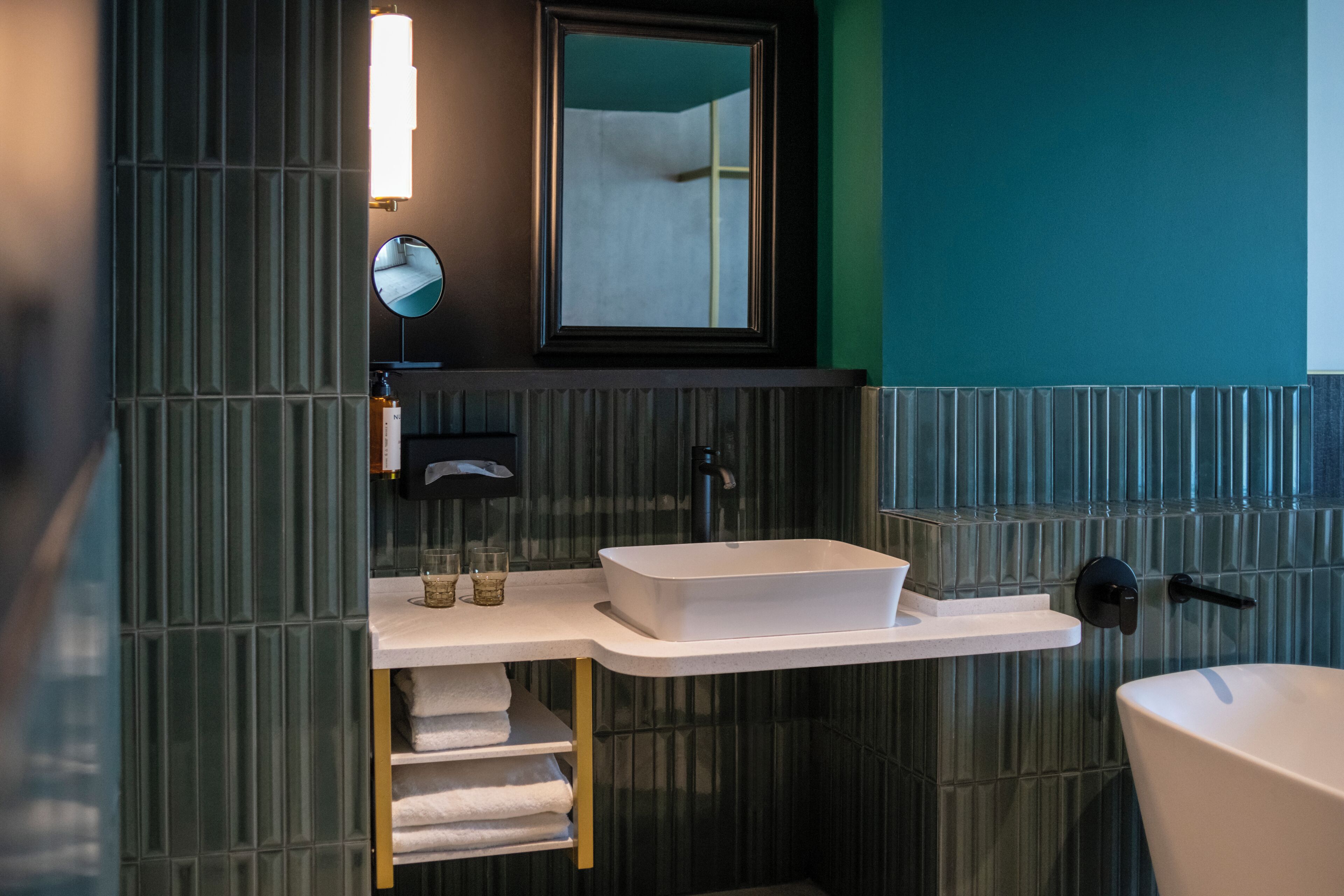 Une salle de bain moderne avec un lavabo rectangulaire, un miroir au-dessus et des toilettes.