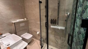 Ein modernes Badezimmer mit einer Duschkabine, einer Toilette und einem Waschbecken.