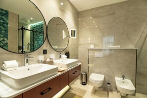 A modern bathroom with two sinks, a bidet, a toilet, and a large mirror. - Mercure Tashkent North (Tashkent)