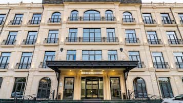 A multi-story hotel with a classic architectural style, featuring a grand entrance with steps leading up to the main doors.