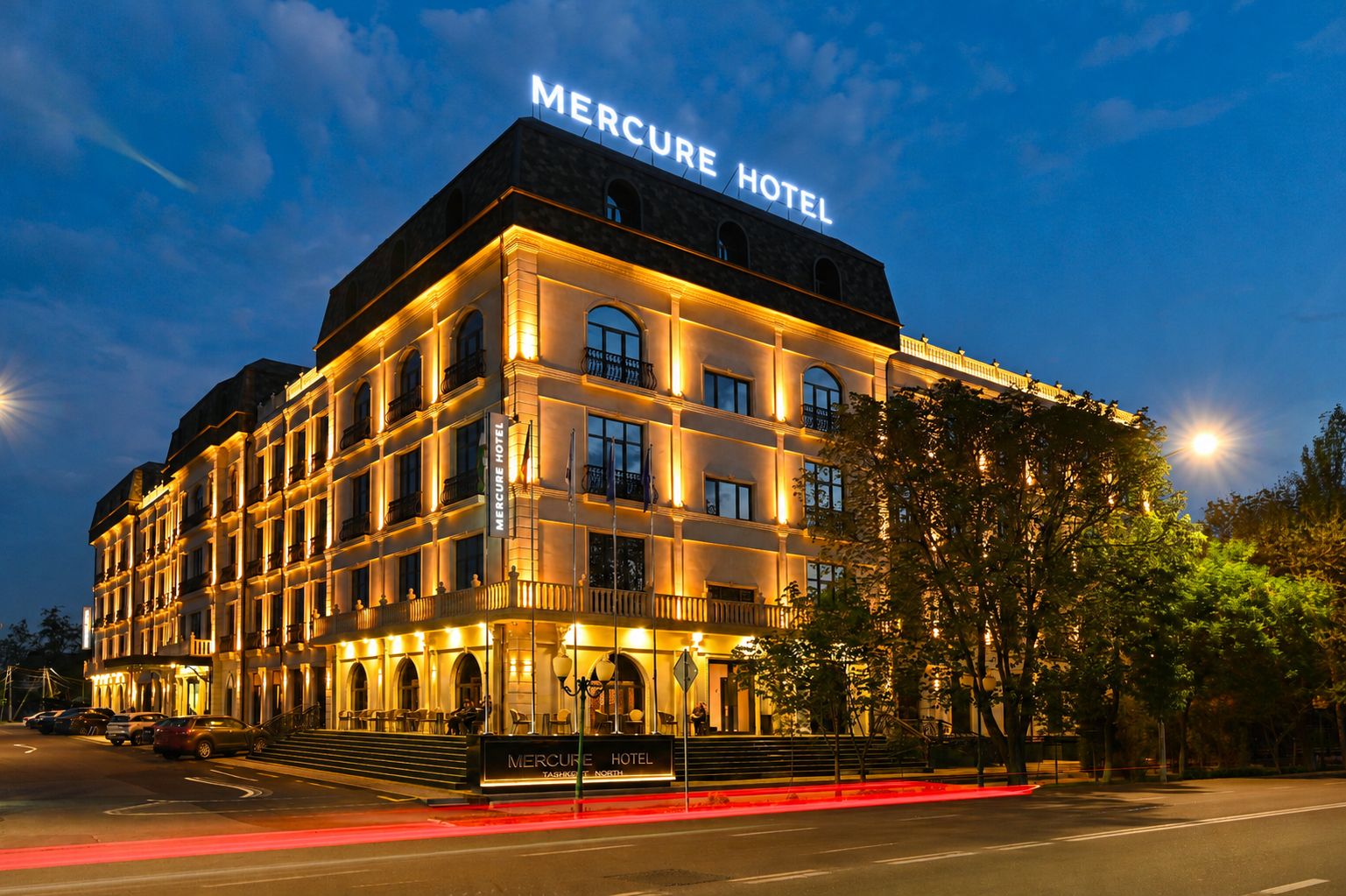 A multi-story hotel with a prominent sign reading 'Mercure Hotel' and a nameplate stating 'Tashkent North.'