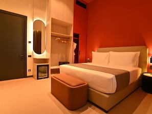 A modern bedroom with a bed, a bedside table, a nightstand, a mirror, a wardrobe, and a small seating area. - Mercure Tashkent North (Tashkent)