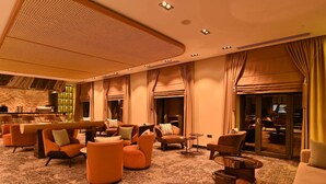 A spacious lobby with multiple seating areas, a reception desk, and a large mirror.
