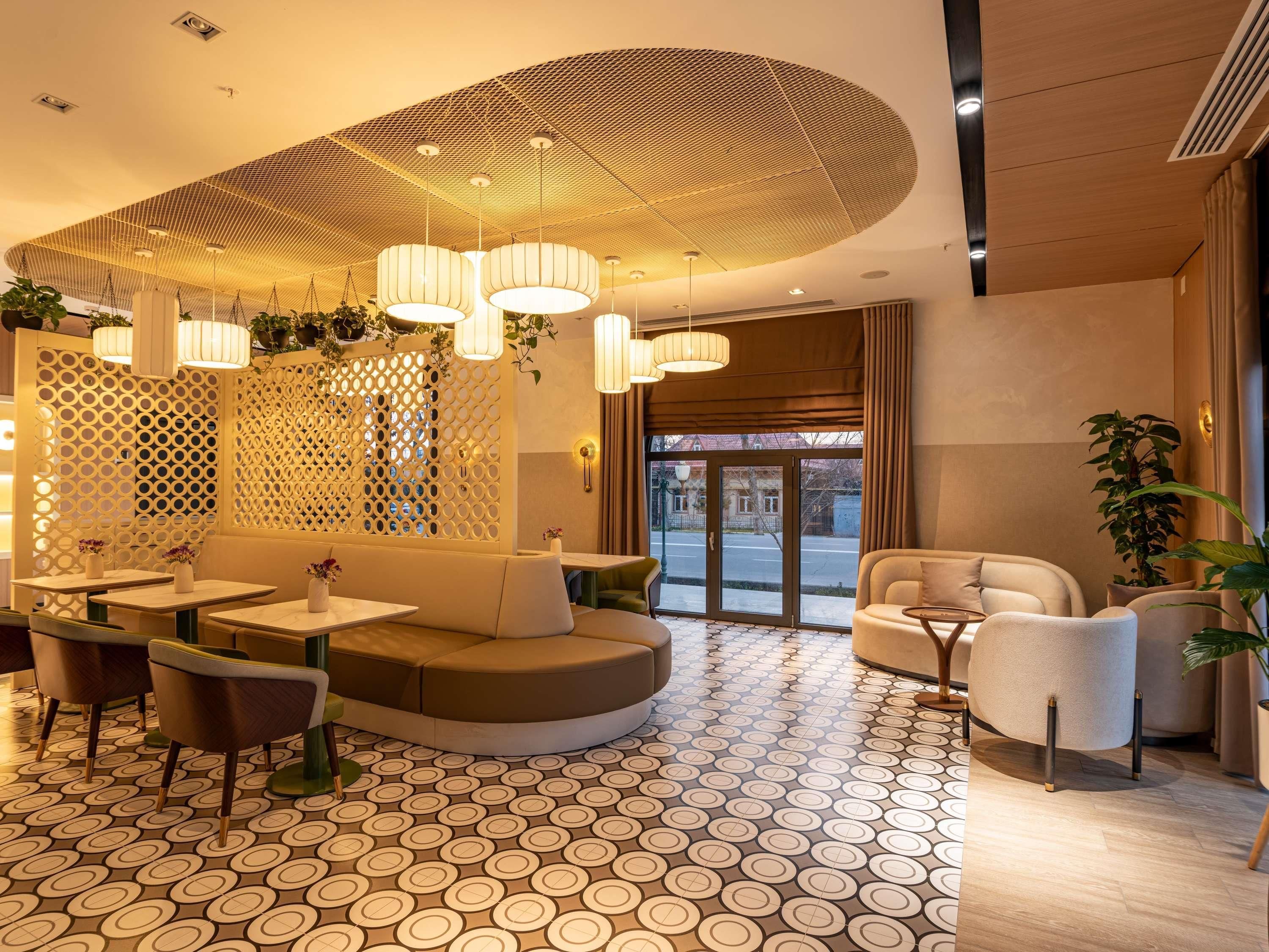 A modern interior with a circular seating area, pendant lighting, and patterned flooring.