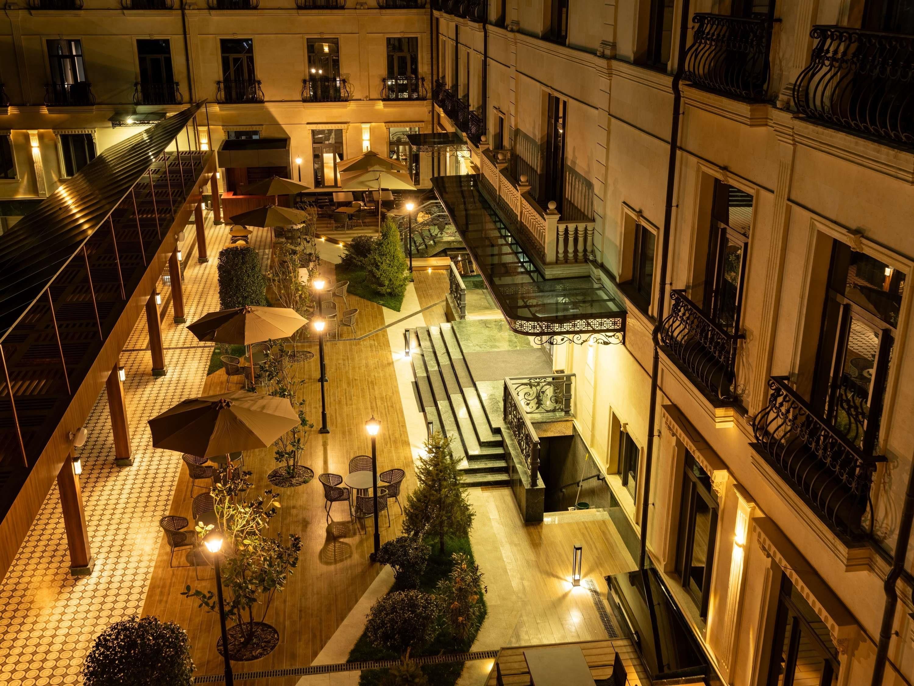 A courtyard with outdoor seating, a staircase, and a building facade.