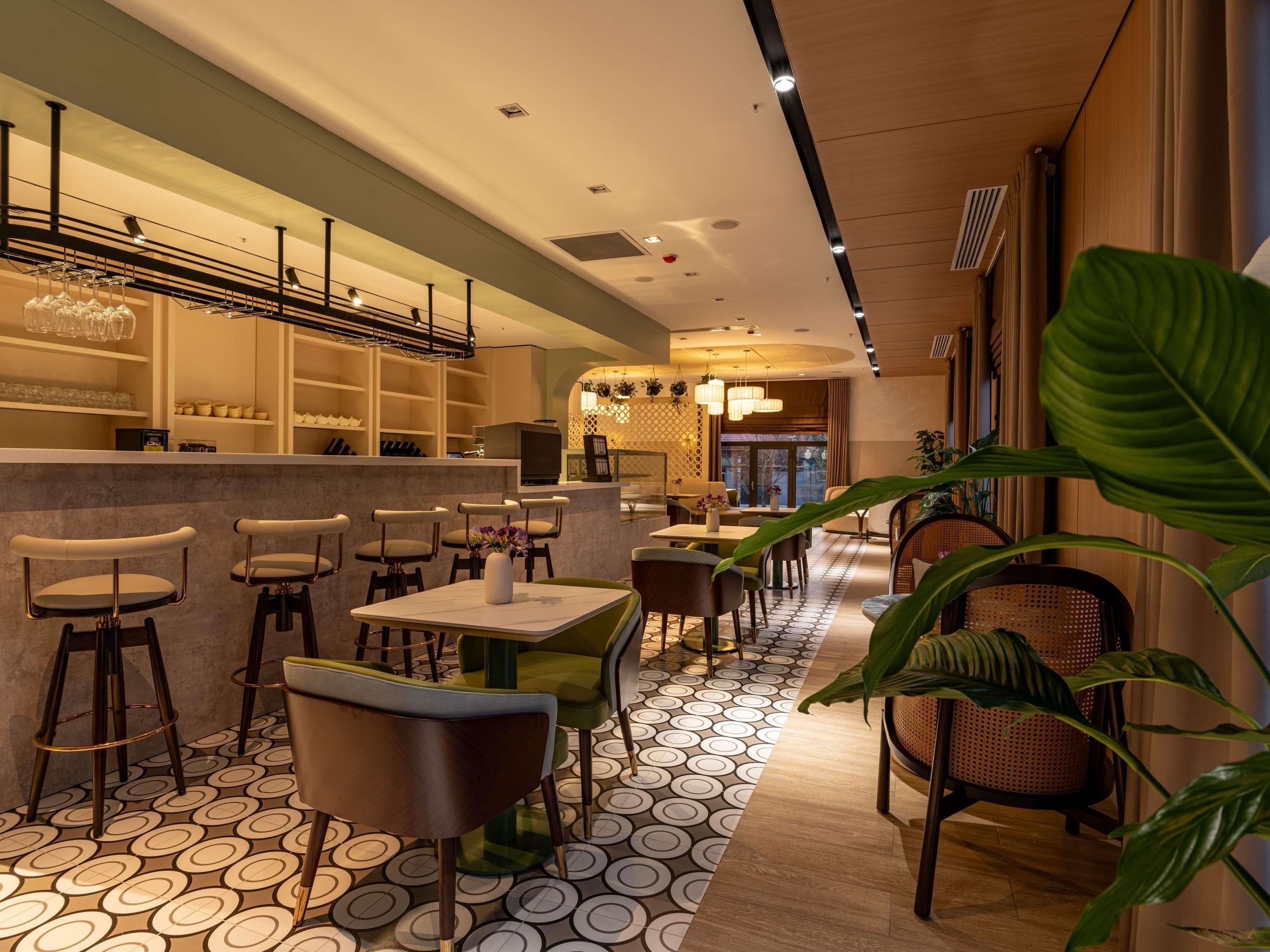 A modern interior with a bar area, seating, and a patterned floor.